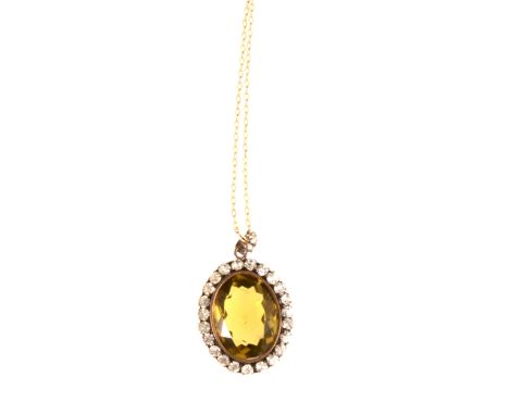 An antique style vintage paste set pendant and chain, an oval faceted citrine coloured paste gem surrounded by clear brillian