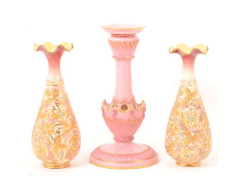 A Royal Worcester candlestick, no. 1236, pink with gilded highlights, wrythen fluted bands, floral rosettes, 20cm; and a pair