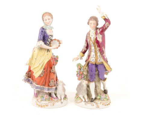 Pair of large Sitzendorf porcelain figures, designed as a man with a sheep and a lady playing a tambourine, 26cm and 24cm.