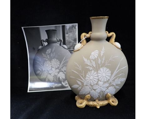 A VICTORIAN MOON FLASK VASE, overlaid with white flowers in relief, supported by gilded serpents, 21cm high