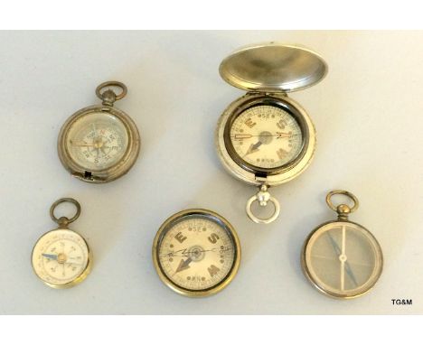 A WW1 nickel pocket compass in a full hunter case, with another similar but missing its lid and three other small compasses