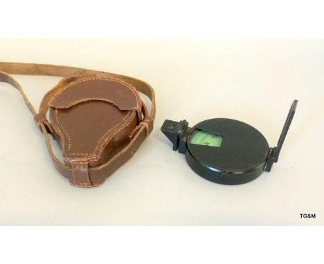 A Prismatic compass in its brown leather case with carry strap
