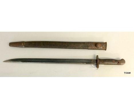 A British pattern 1907 bayonet in its leather scabbard with metal mounts. Blade length 43cms