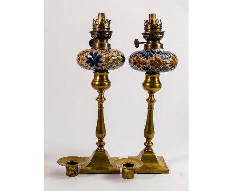 Pair of Royal Doulton Lambeth oil lamps: Fitted on brass stems with oil lamp fittings, each with an additional candlestick br