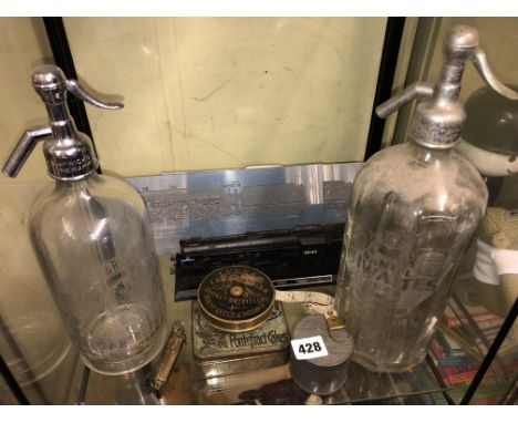 TWO VINTAGE SODA SYPHONS, VINTAGE ENAMEL TINS, LAWN TENNIS OUTFITTERS TAPE MEASURE, LIGHTER AND TRAIN MODEL