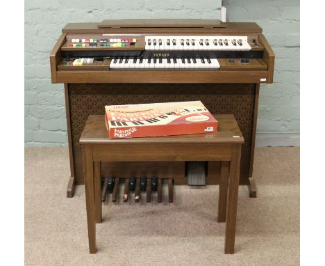A Yamaha Electone A-55N electric organ with original cover, stool manual and sheet music.