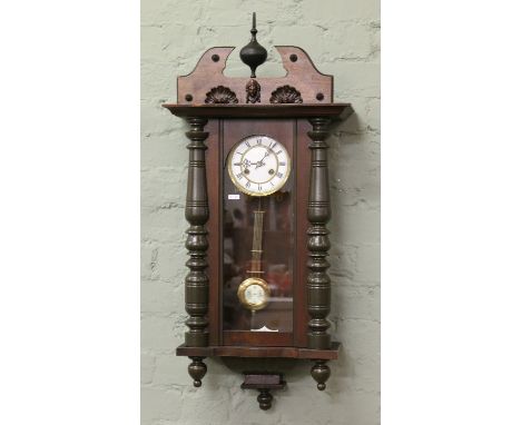 A Victorian mahogany eight day Vienna wall clock with brass and enamel dial and striking on a coiled gong.