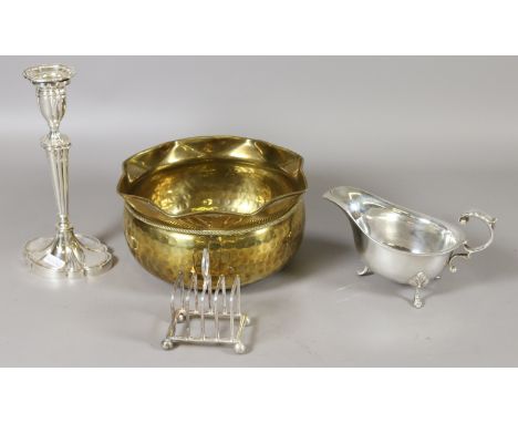 A silver plated candlestick, sauceboat and small toast rack, along with a planished brass planter.