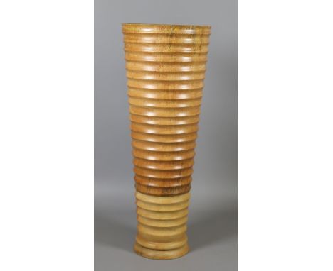 A turned wood stick stand of tapering form and with ribbed decoration. 