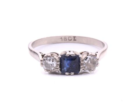 A sapphire and diamond three-stone ring, centred with a square step-cut sapphire of dark blue colour, approximately measures 