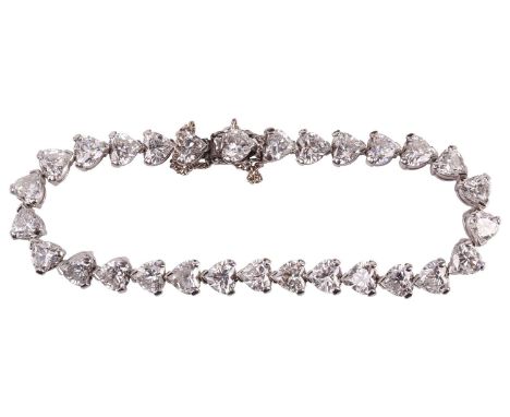 A diamond tennis bracelet in platinum, set with twenty-nine heart-shaped diamonds, each weighing an average of 0.60ct, with a