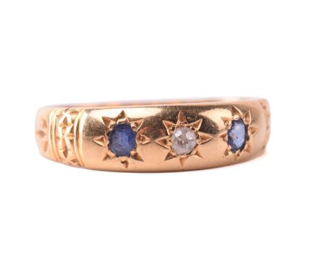 A sapphire and diamond three-stone gypsy ring in 18ct gold, centred with an old-cut diamond and flanked by two cushion-shaped