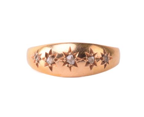 A Victorian gypsy ring with five rose cut diamonds in star settings to a wide gold band with hallmarks for 18ct gold and date