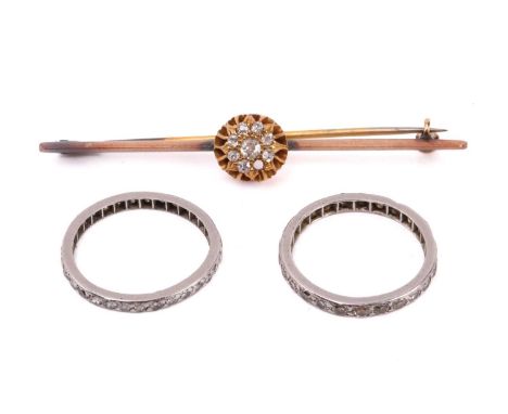 A diamond cluster bar brooch together with two diamond eternity rings. The brooch set with a cluster of old cut diamonds (one