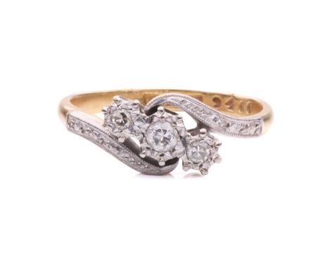 A three-stone diamond crossover ring, with a circular-cut diamond flanked by two single-cut diamonds in illusion settings, to