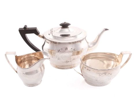 An Edward VII three-piece silver tea set, Sheffield 1902 by Henry Stratford, comprising a teapot engraved with a crest, with 