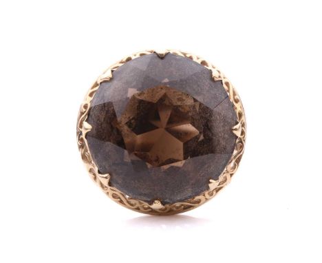 A solitaire smokey quartz ring featuring a smokey quartz measuring 20mm diameter x 10mm, claw set to a scrolling gallery and 