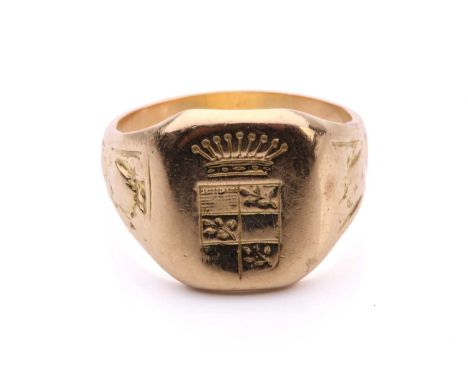 A signet ring with a heraldic design, the cushion-shaped ring head engraved with a crowned escutcheon, to floral motifs adorn
