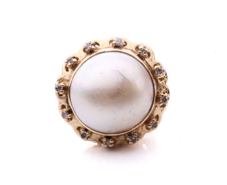 A pearl and diamond ring set with a central mabe pearl measuring 16mm diameter encircled by twelve round brilliant cut diamon