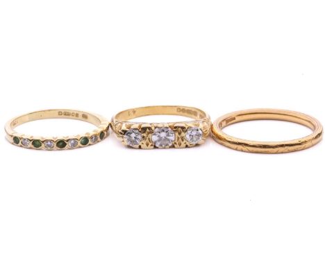 A 22ct gold wedding band and two 18ct gold gem-set rings; the wedding band with a court-profile band, has intricate pattern e