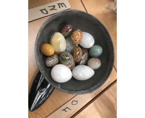 An Arts &amp; Crafts pewter bowl containing hardstone eggs, a polished fossil specimen, and an agate slice. 