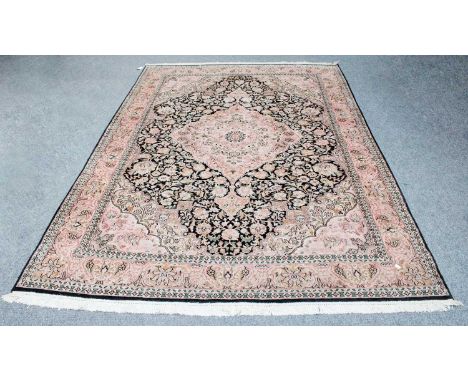 Kashmir Silk Piled Carpet, the charcoal field of vines centered by a candy pink medallion framed by spandrels and borders of 