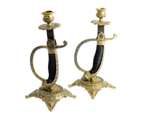 A pair of World War One German sword hilt candle holders, the column formed as a dagger in scabbard, with star base on scroll