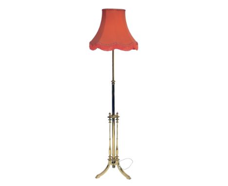 A 20thC brass standard lamp, a cylindrical column with triform column base, on out splayed legs, with shade, 190cm high overa