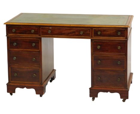 An early 20thC mahogany pedestal desk, the top with green tooled leather inset, with an arrangement of nine drawers, on brack