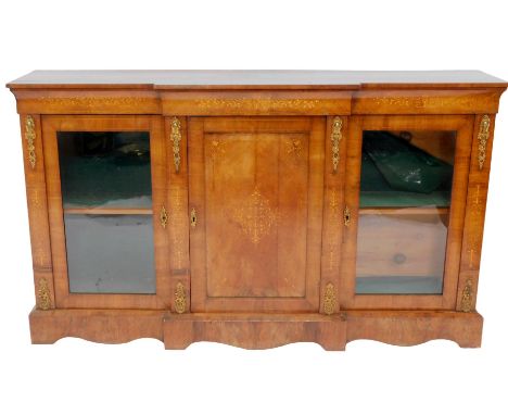 A Victorian figured walnut, inlaid and ormolu mounted credenza, the breakfront top above a panelled cupboard flanked by two g