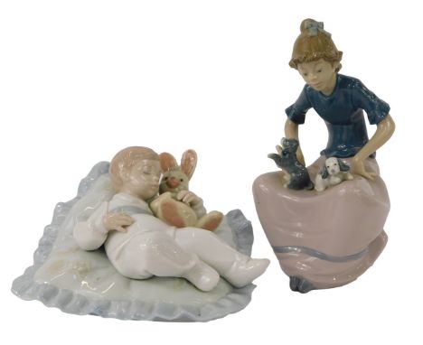 A Lladro porcelain figure, modelled as a child seated on cushion with rabbit, 14cm high, together with a Nao porcelain figure