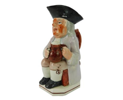 A 19thC pottery Toby jug, modelled as a seated gentleman wearing a tricorn hat holding a tankard of beer and pipe, 26cm high.