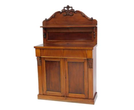 A Victorian mahogany chiffonier, the raised back with a scroll carved top and shelf above a shelf, the base with two cupboard