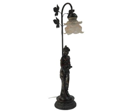 A 20thC table lamp, with frosted pink shade, the lamp base with leaf decoration and the stem surmounted by a figure of a lady