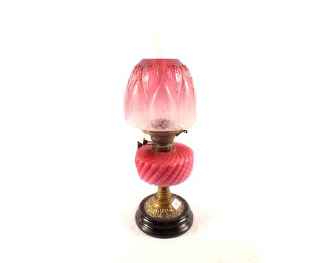 A brass column oil lamp with pink satin glass bowl and etched shade