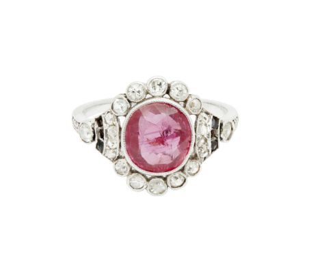 An early 20th century ruby and diamond set ringmillegrain set with an off-round cut ruby, in a border of similarly set eight 
