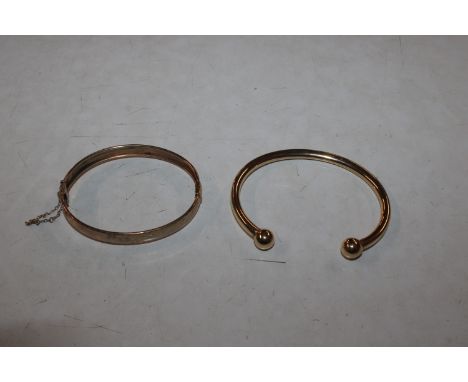 A 9ct gold bangle, 8.5gms and a yellow metal snap bangle, 10gms 