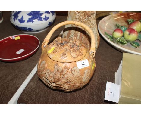 A Bernard Rooke pottery biscuit barrel with raised frog and lily pad decoration with wicker swing handle