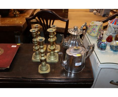 Two pairs of brass candlesticks; a single brass candlestick and two silver plated tea pots 