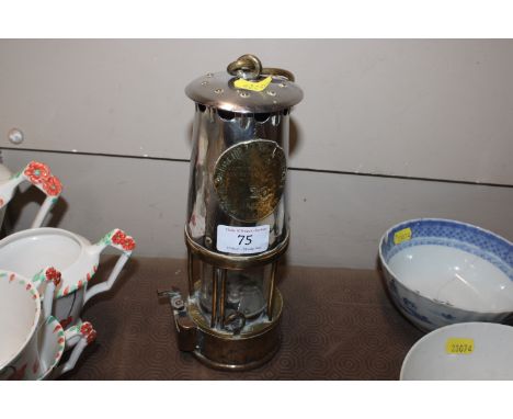 A brass and polished metal miners lamp