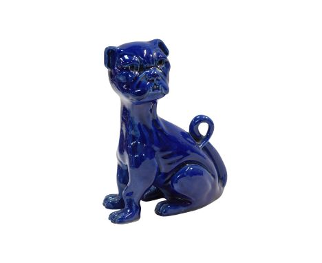An Aller Vale Devon pottery dog, in seated pose, blue glaze, 18cm high.