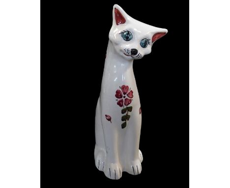 An H Brannam Devon pottery cat, decorated with flowers against a white ground, printed marks, 30cm high.