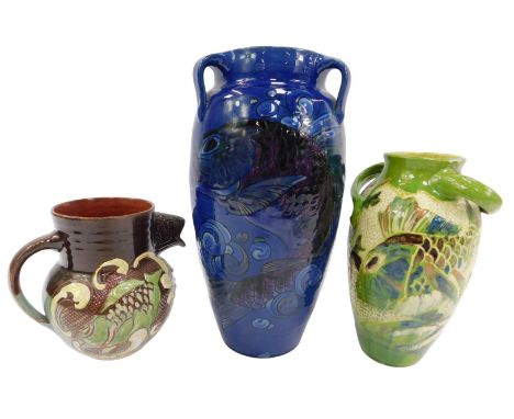 Two CH Brannam Barnstaple earthenware pottery vases and a jug, all with fish decoration, the large blue glazed jug with three