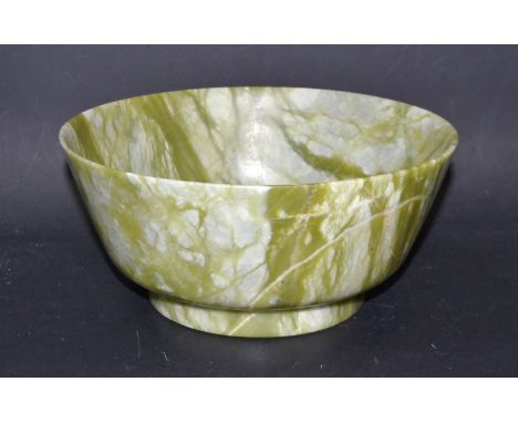 A light green onyx lapidary circular bowl, white and brown inclusions and striations throughout, turned foot, 20cm diam, 9cm 
