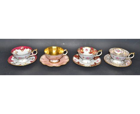 A Royal Crown Derby trial cup and saucer, in gilt on a salmon ground, gilded interior; three other similar floral printed tri