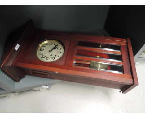 A vintage wall mounted clock with aged style face plate