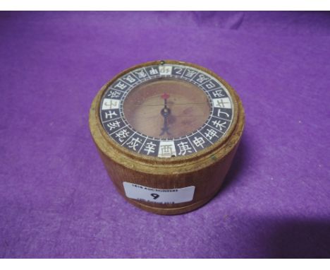 A vintage compass with wooden body and Oriental markings