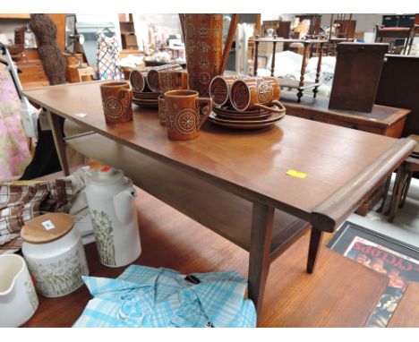 A 60's design teak top coffee table with integral shelf