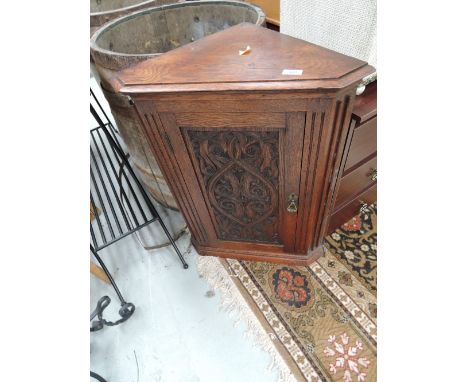 A 19th Century oak corner cupboard having carved panel door