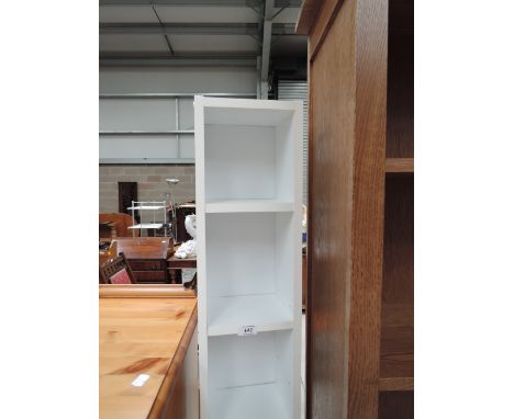 A white narrow laminate shelf unit